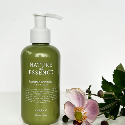 Sfeerbeeld van het oolaboo nature as essence time to time haarmasker, in een olijfgroene fles met witte pomp.